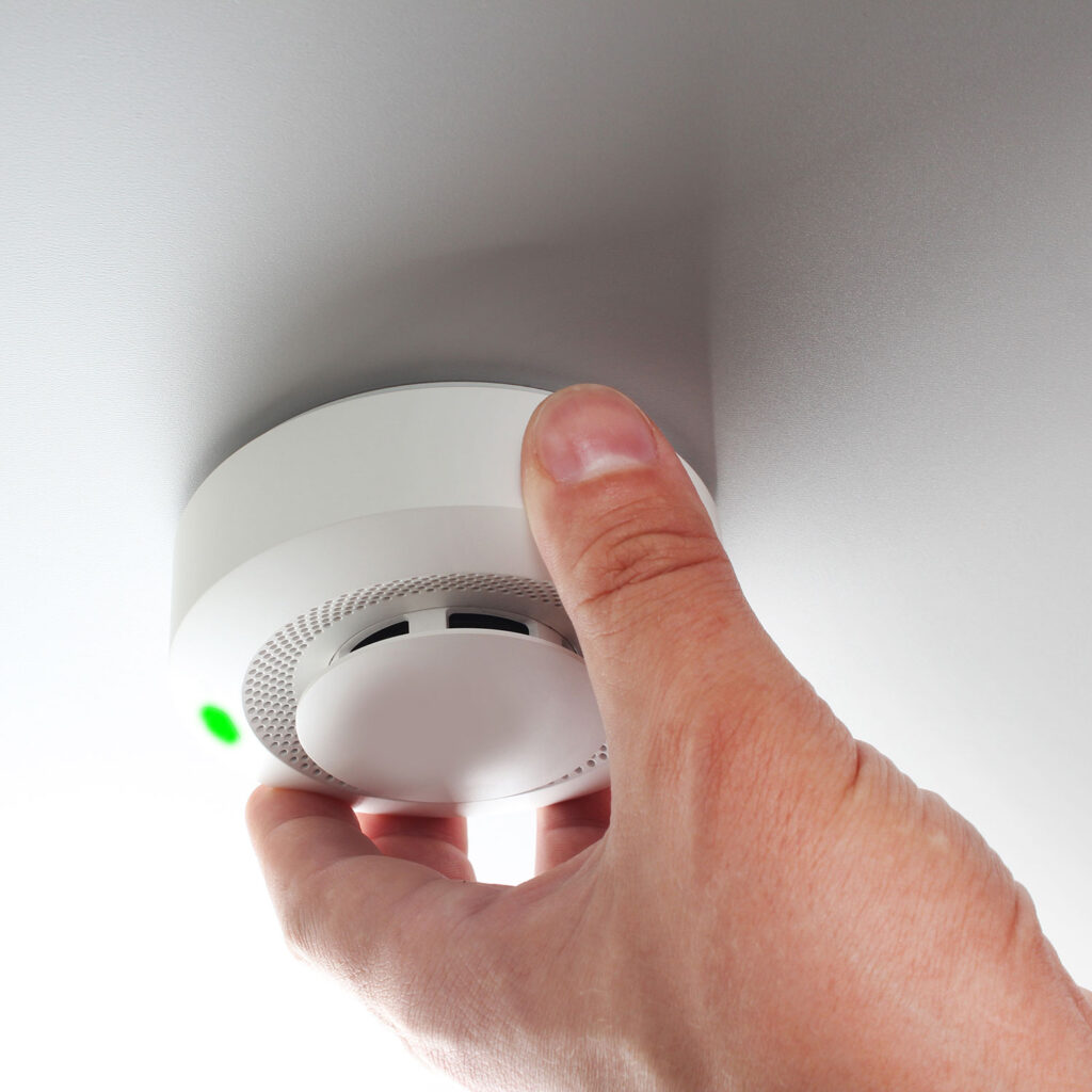 hand on smoke alarm